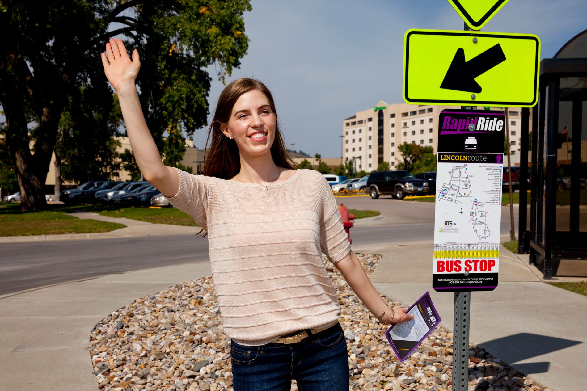 Young woman waving at RapidRide stop